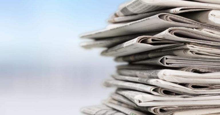News roundup with a stack of newspapers