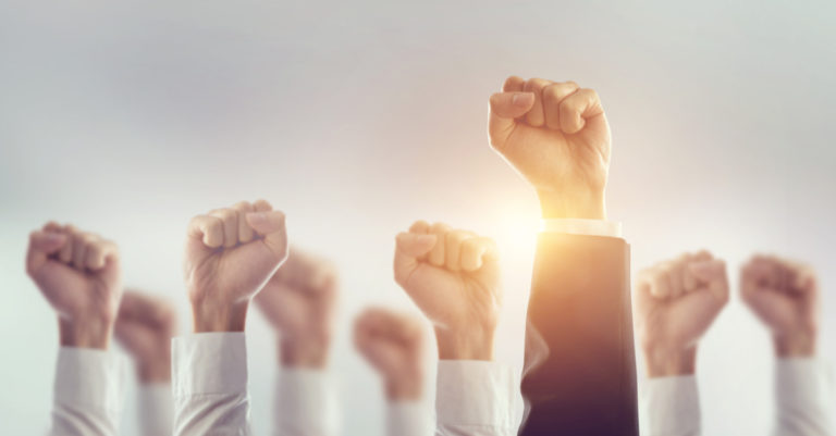 Implementation and change management represented by fists in the air