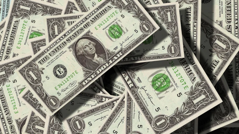 Many one dollar bills lying on top of each other