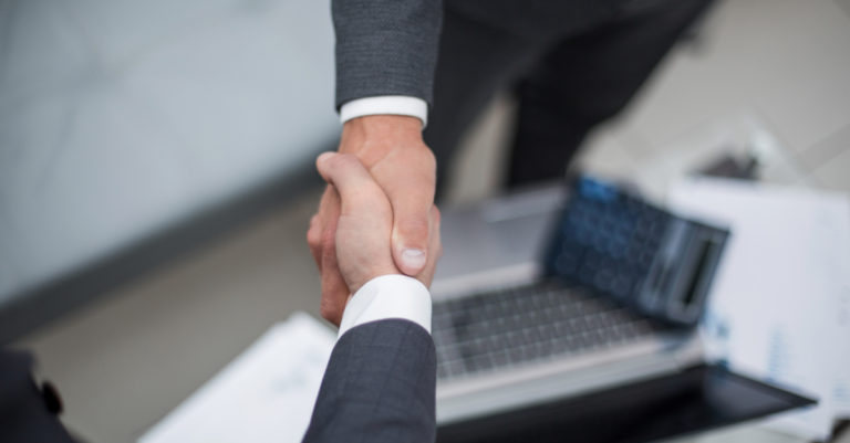 7 metrics for company performance represented by business people shaking hands