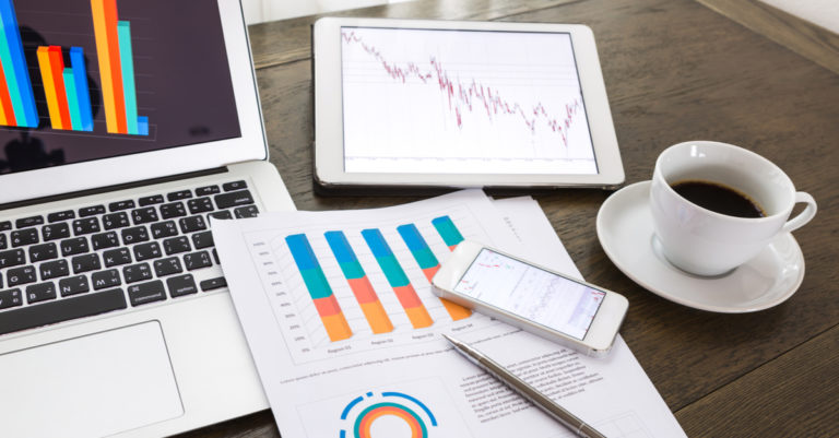 Legal ops maturity worksheet with papers and devices on desk